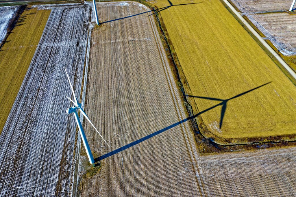 High-angle shot of wind turbines casting shadows on farmland in Dodge Center, MN.