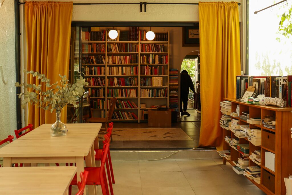 Warm and inviting bookstore interior with yellow curtains and red chairs, perfect for book lovers.